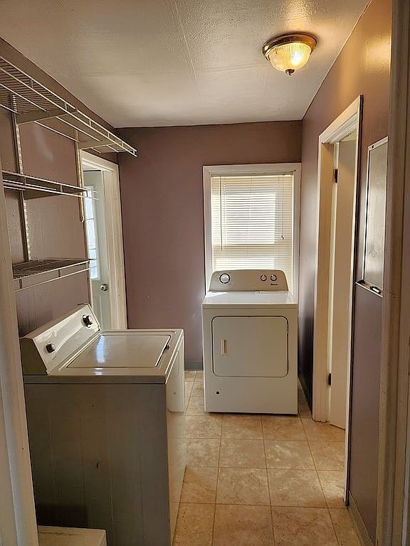 946 Miller Ave, Iowa City, IA 52246 - laundry room with light tile patterned flooring, a wealth of natural light, independent washer and dryer, and laundry area