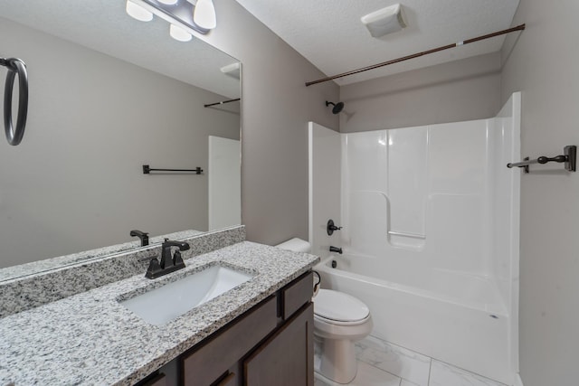 bathroom featuring marble finish floor, toilet, shower / bath combination, vanity, and a textured ceiling