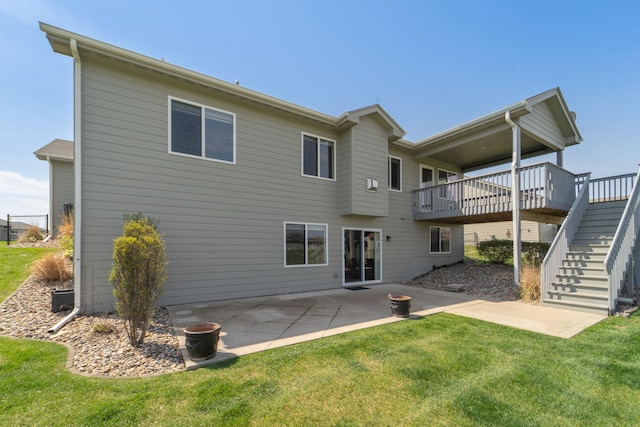 rear view of property with a lawn, a patio area, a wooden deck, and stairs