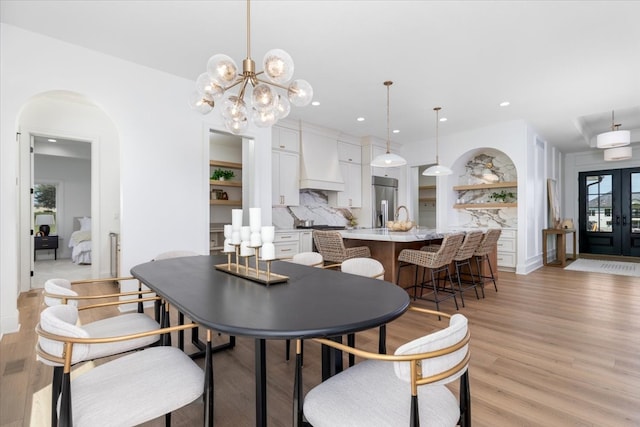 18284 Baxter Pl, Clive, IA 50325 - dining room featuring arched walkways, light wood-type flooring, recessed lighting, and a chandelier