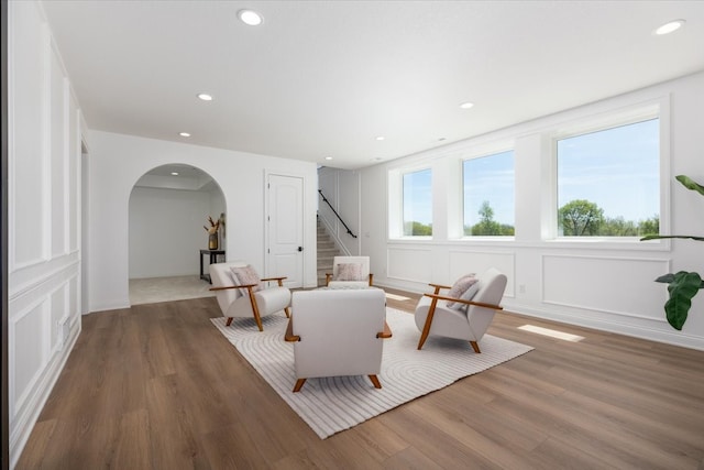 18284 Baxter Pl, Clive, IA 50325 - living area featuring arched walkways, wood finished floors, recessed lighting, stairway, and a decorative wall