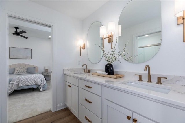18284 Baxter Pl, Clive, IA 50325 - full bathroom with double vanity, connected bathroom, wood finished floors, and a ceiling fan