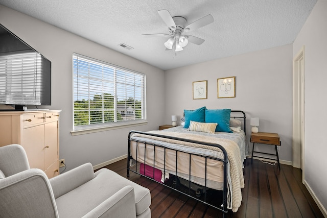 bedroom featuring a textured ceiling, visible vents, wood finished floors, and baseboards
