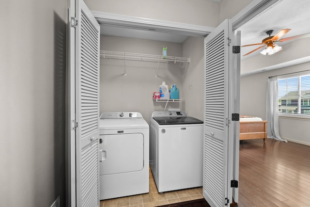 washroom with laundry area, light wood-style floors, ceiling fan, baseboards, and washer and clothes dryer