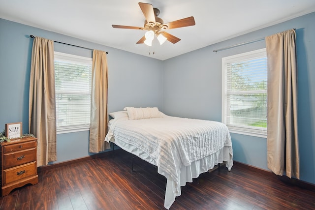 bedroom with baseboards, wood-type flooring, and multiple windows