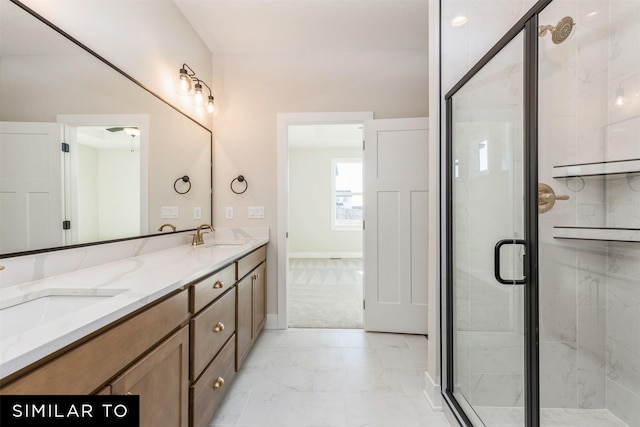 full bath featuring a stall shower, baseboards, marble finish floor, and a sink