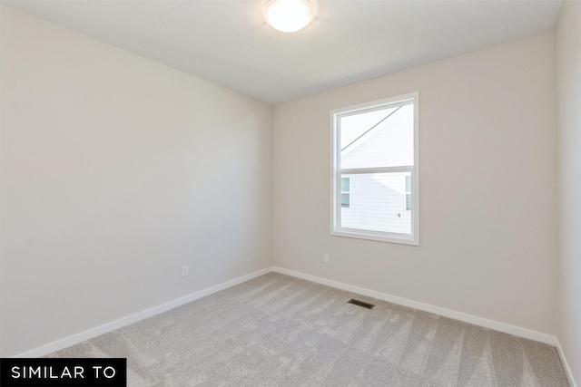 unfurnished room with baseboards, visible vents, and light carpet