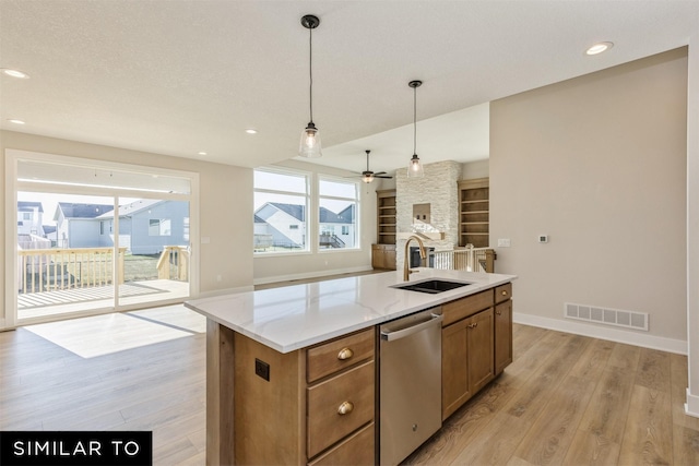 kitchen featuring a sink, light wood-style floors, visible vents, stainless steel dishwasher, and open floor plan