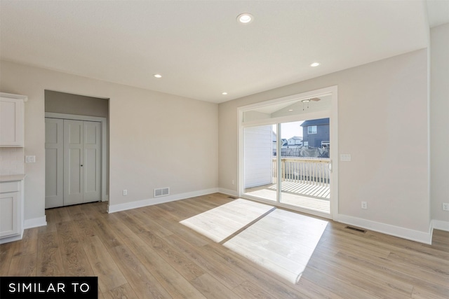 empty room with baseboards, visible vents, light wood-style flooring, and recessed lighting