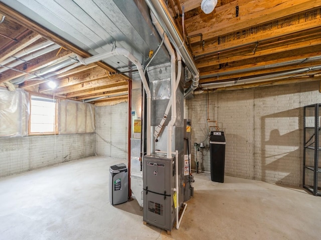 below grade area featuring heating unit and brick wall