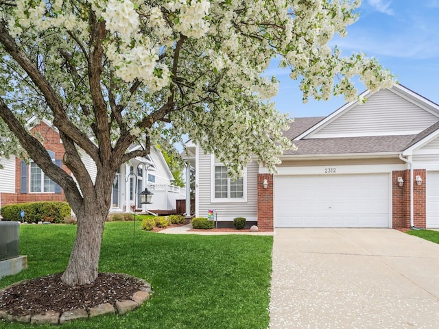 view of front of house featuring brick siding, a shingled roof, driveway, a front lawn, and an attached garage