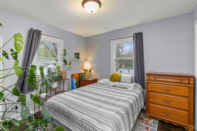 bedroom with a textured ceiling and multiple windows