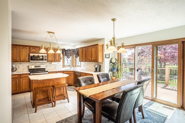 dining area with visible vents, light tile patterned floors, and a textured ceiling