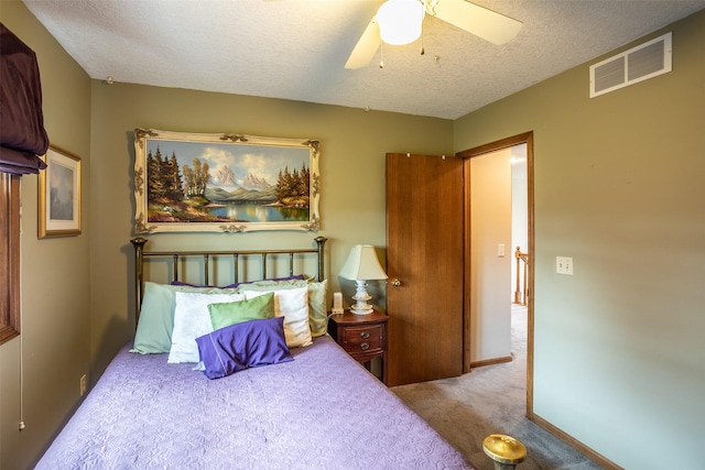 bedroom featuring visible vents, ceiling fan, a textured ceiling, and carpet