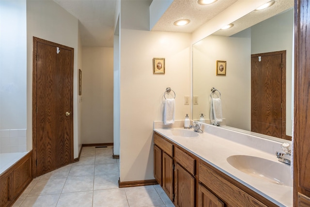full bath with double vanity, baseboards, tile patterned flooring, and a sink