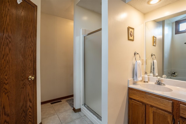 full bathroom featuring tile patterned flooring, visible vents, a shower stall, and vanity