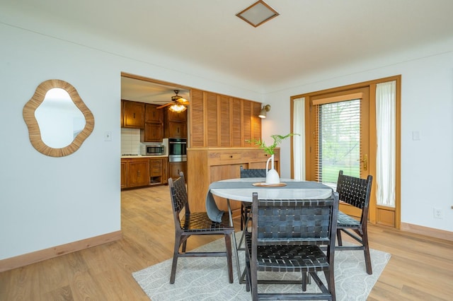dining area featuring ceiling fan, light wood-style flooring, and baseboards