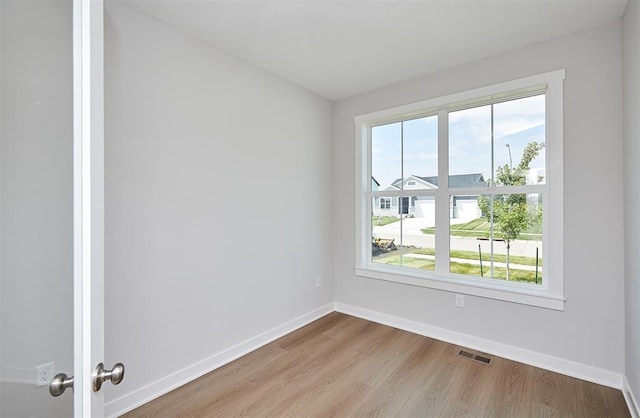 unfurnished room with visible vents, baseboards, and plenty of natural light