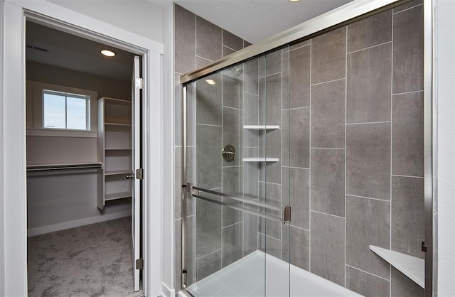 bathroom featuring visible vents, recessed lighting, a stall shower, and a walk in closet