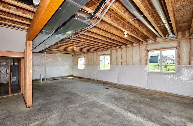 basement featuring a healthy amount of sunlight and water heater