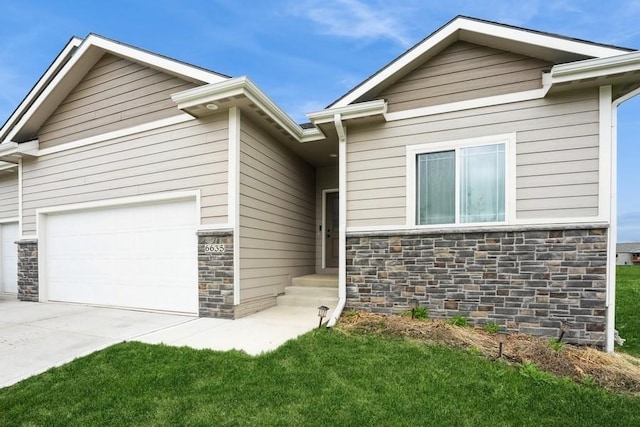 6635 NE 9th Ct, Des Moines, IA 50313 - view of front facade with concrete driveway, a front yard, an attached garage, and stone siding
