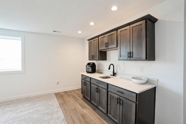 6635 NE 9th Ct, Des Moines, IA 50313 - kitchen with a sink, visible vents, light countertops, baseboards, and recessed lighting