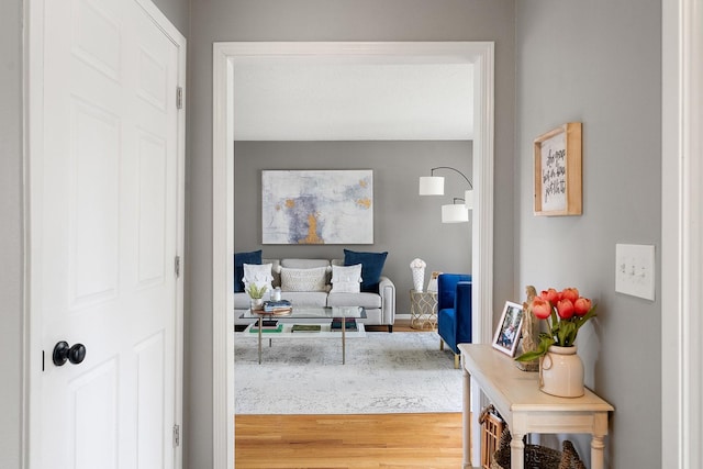 corridor with baseboards and wood finished floors
