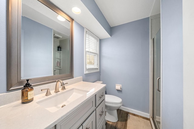 bathroom featuring a shower stall, baseboards, toilet, wood finished floors, and vanity
