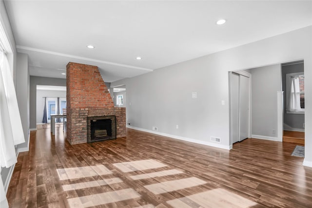 unfurnished living room with recessed lighting, visible vents, wood finished floors, and baseboards