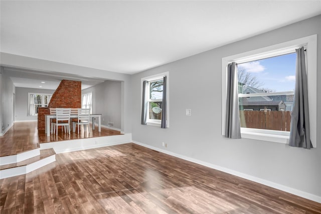 unfurnished living room featuring wood finished floors and baseboards