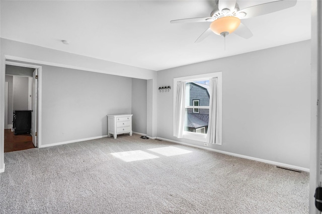 unfurnished bedroom with baseboards, visible vents, a ceiling fan, and carpet floors