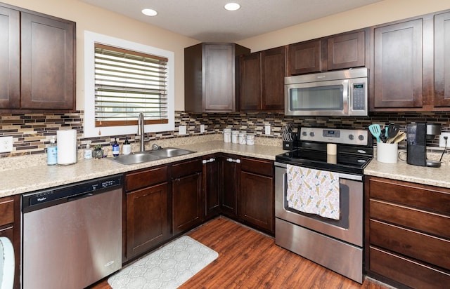 2884 Park Pl, Norwalk, IA 50211 - kitchen with stainless steel appliances, a sink, light countertops, backsplash, and recessed lighting