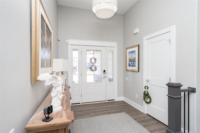 foyer entrance featuring baseboards and wood finished floors
