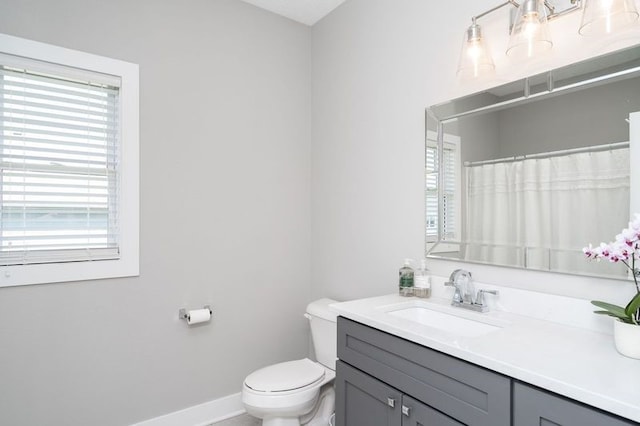bathroom with vanity, toilet, and baseboards