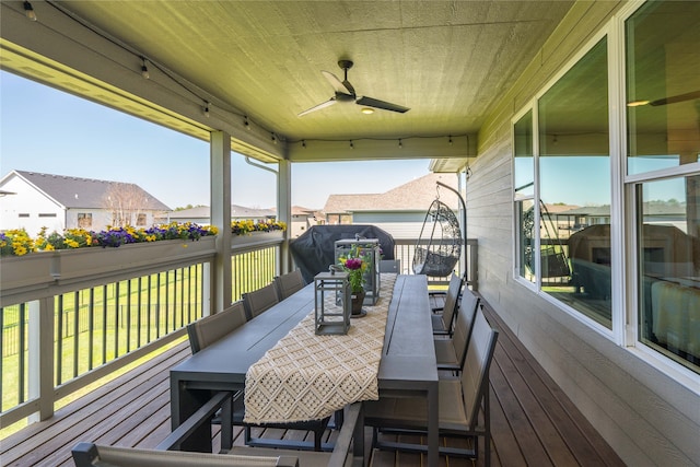 wooden deck featuring a residential view, outdoor dining area, and ceiling fan