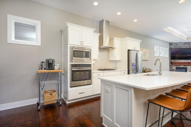1616 Park Ave, Des Moines, IA 50315 - kitchen featuring stainless steel appliances, wall chimney range hood, dark wood-type flooring, light countertops, and recessed lighting