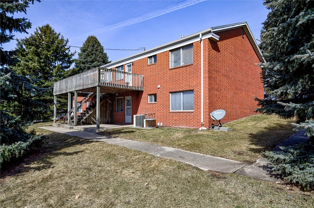 180 1st St, Gilbert, IA 50105 - back of house with a lawn, stairway, brick siding, and a wooden deck