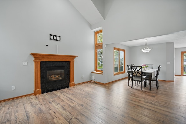 1410 Alderwood Dr, Altoona, IA 50009 - dining space with hardwood / wood-style floors, high vaulted ceiling, a fireplace, and baseboards