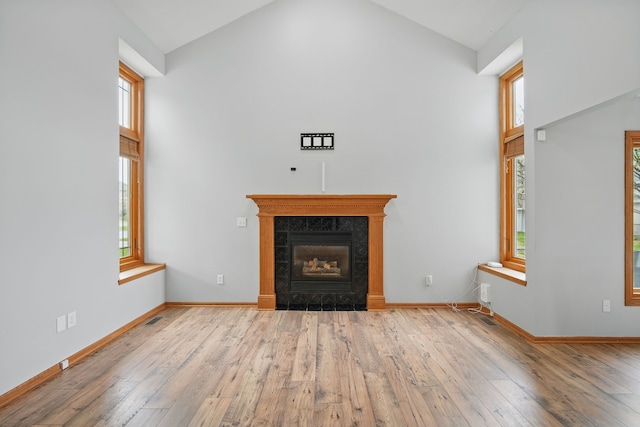 1410 Alderwood Dr, Altoona, IA 50009 - unfurnished living room with high vaulted ceiling, wood finished floors, a fireplace, and plenty of natural light