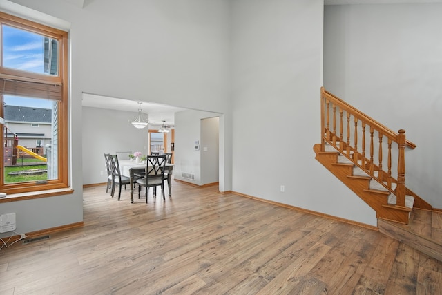 1410 Alderwood Dr, Altoona, IA 50009 - interior space with an inviting chandelier, stairs, baseboards, a towering ceiling, and wood finished floors