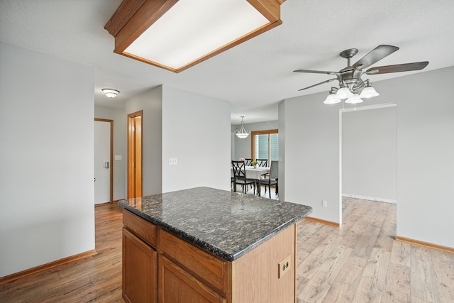 1410 Alderwood Dr, Altoona, IA 50009 - kitchen featuring baseboards, light wood-type flooring, a ceiling fan, and a kitchen island