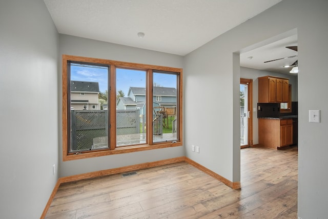 1410 Alderwood Dr, Altoona, IA 50009 - unfurnished room with visible vents, ceiling fan, baseboards, and light wood-style floors