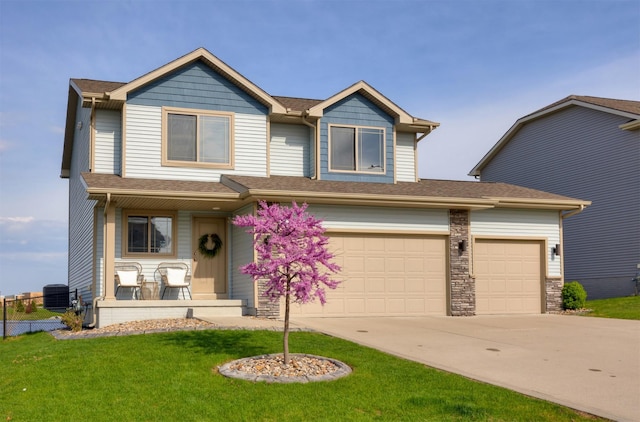 craftsman house with covered porch, driveway, roof with shingles, central AC, and a front yard