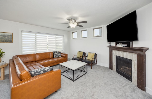 carpeted living area featuring baseboards, a ceiling fan, and a fireplace
