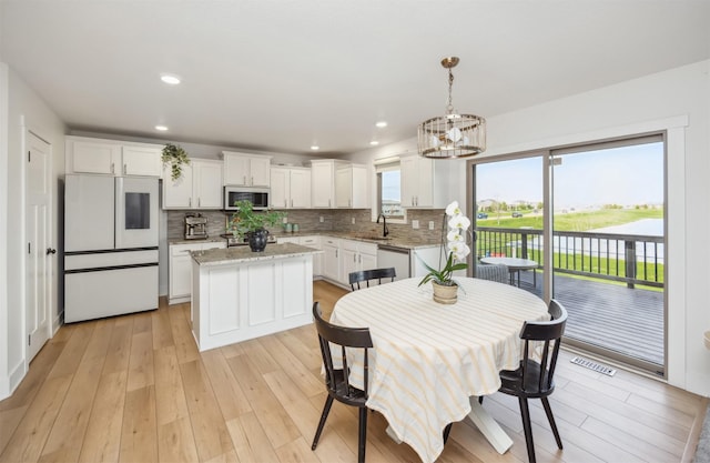 dining area featuring visible vents, light wood-style floors, recessed lighting, and a notable chandelier