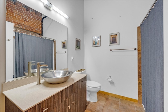 bathroom with toilet, curtained shower, vanity, and baseboards