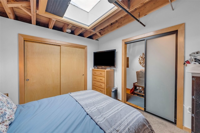 bedroom featuring a skylight, a closet, and light colored carpet