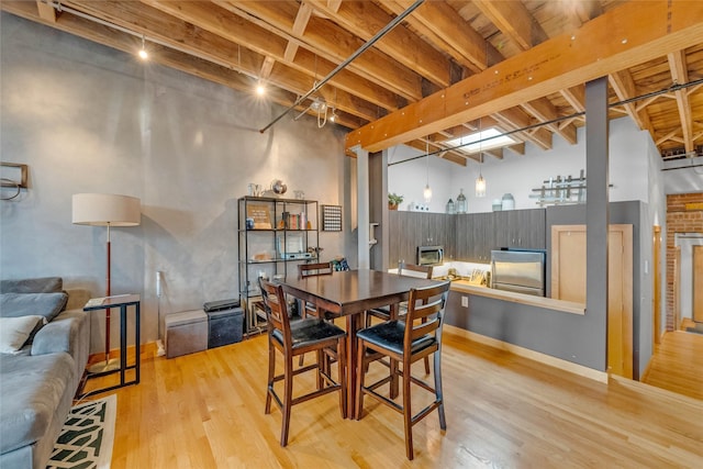 dining space featuring beam ceiling and light wood finished floors