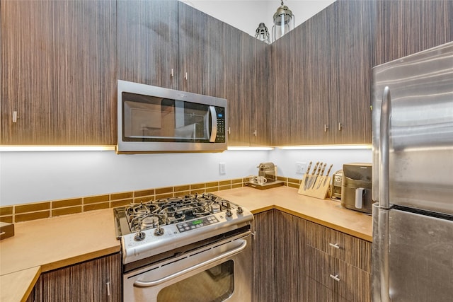 kitchen with appliances with stainless steel finishes, modern cabinets, and light countertops