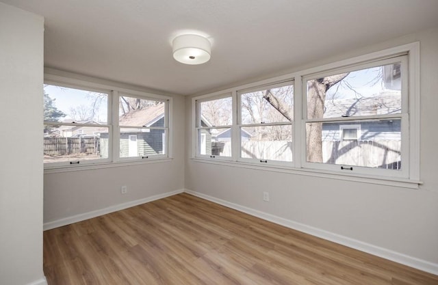 empty room featuring baseboards and light wood-style flooring